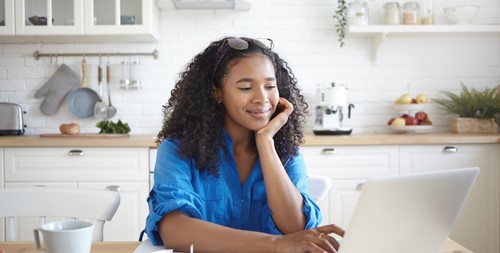 An employee using a laptop in a kitchen