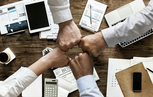 employees fist bumping during a meeting