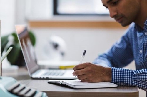 An employee making notes at their desk